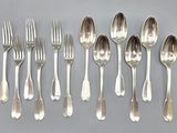 a lot of silver spoons and forks on the table