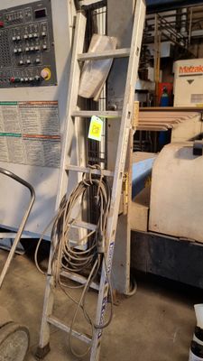 une photo d'une pièce avec une échelle, une chaise et une machine