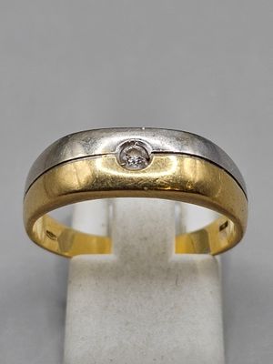 une alliance en or jaune et en or blanc sertie d'un diamant