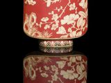 a red and white vase with a bird on it