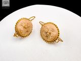 pair of carved cameos of a woman with flowers on them