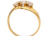 a close up of a gold ring with three diamonds on it