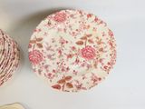 une assiette décorée d'un motif floral, à côté d'un bol avec une cuillère