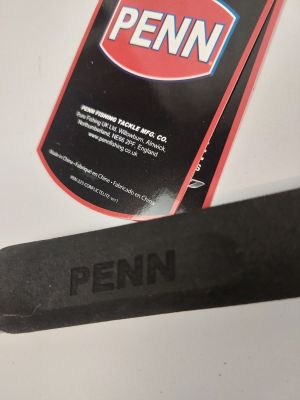 a close up of a pair of scissors next to a bottle of penn