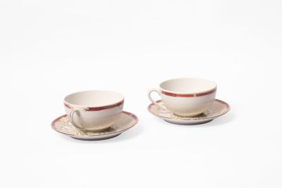 deux tasses et soucoupes sont posées sur une surface blanche