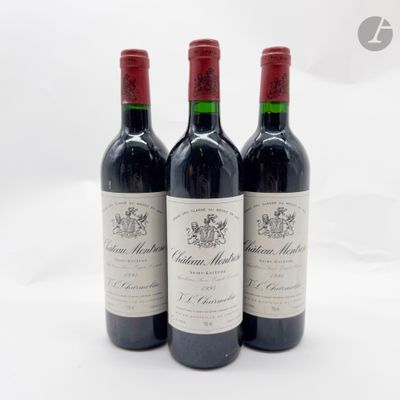 trois bouteilles de vin rouge posées sur une table blanche