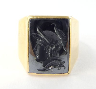 bague en or jaune ornée d'un onyx noir représentant un dragon et son cavalier