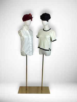 two mannequins dressed in white and black are standing next to each other