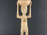 une statue représentant une femme tenant un pot sur la tête