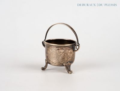 une vieille théière en argent posée sur une table blanche