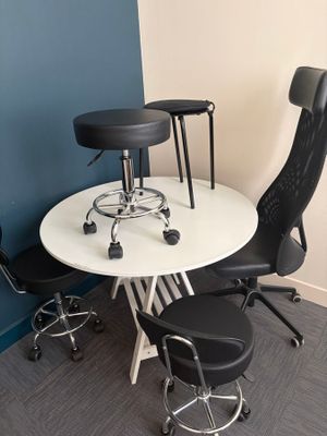 a white table with black chairs and a white table with a black chair