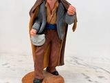 figurine représentant un vieil homme coiffé d'un chapeau et portant un gilet, tenant un seau