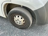 a white truck with a flat tire parked in a parking lot