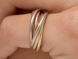 quelqu'un tient dans sa main une bague en or et en argent