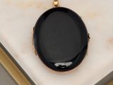 an image of a black pendant sitting on top of a marble table