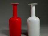 deux vases rouges et blancs posés l'un à côté de l'autre sur une surface grise