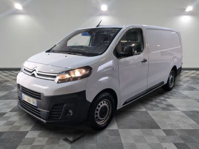 the white van is parked in a large room with a checkered floor