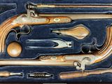a box with a bunch of old guns in it