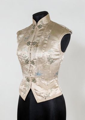 une robe de mannequin avec une veste en brocart doré et argenté