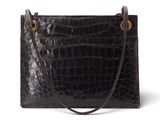 un sac à main en cuir de crocodile noir sur fond blanc