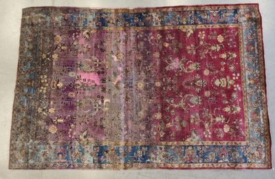 un vieux tapis orné d'un motif rose et bleu