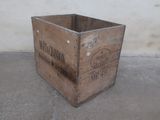 a wooden crate sitting on the floor in front of a wall