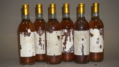 six bouteilles de vin sont alignées sur une table