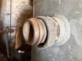 a large metal pipe with a wooden handle in a room