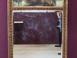 a large mirror with a painting on it in a room