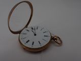 a gold pocket watch with roman numerals on it