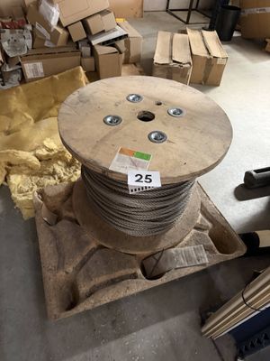 une bobine de fil métallique posée sur une palette dans un entrepôt