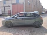 a small grey car parked in front of a building