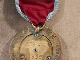 an old medal with a red ribbon is on display in a museum