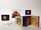 three boxes with different types of candles on them on a white surface