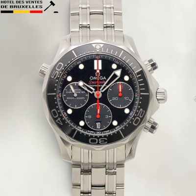La montre possède un cadran noir et une trotteuse rouge.