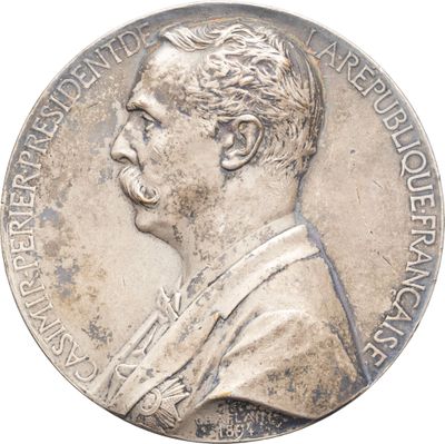 une vieille médaille en argent sur laquelle figure le portrait d'un homme