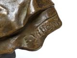bronze statue of a man with a hat on top of his head