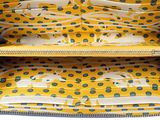 a close up of a yellow purse with blue dots on it