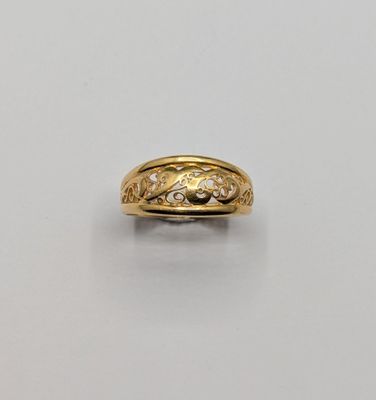 a close up of a gold ring with diamonds on a white surface