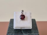 a close up of a ring with a red stone in it