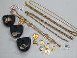 plusieurs bijoux dorés et noirs, notamment un médiator, un collier, un bracelet et une bague
