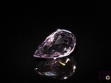 a close up of a purple diamond on a black surface