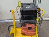 une machine orange et noire posée sur un chariot jaune