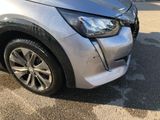 the front end of a silver car with a denting dent on it ' s bumper