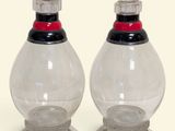paire de salières et poivrières en verre transparent avec des couvercles rouges