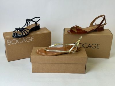 three pairs of women ' s shoes in boxes on a white surface