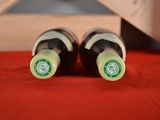 two bottles of wine sitting next to each other on a table