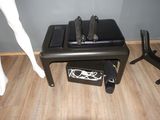 une petite table sur laquelle est posé un ordinateur portable, à côté d'un mannequin