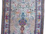 a white rug with a vase of flowers and birds on it