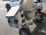 a small cart with a toilet on it in a parking lot